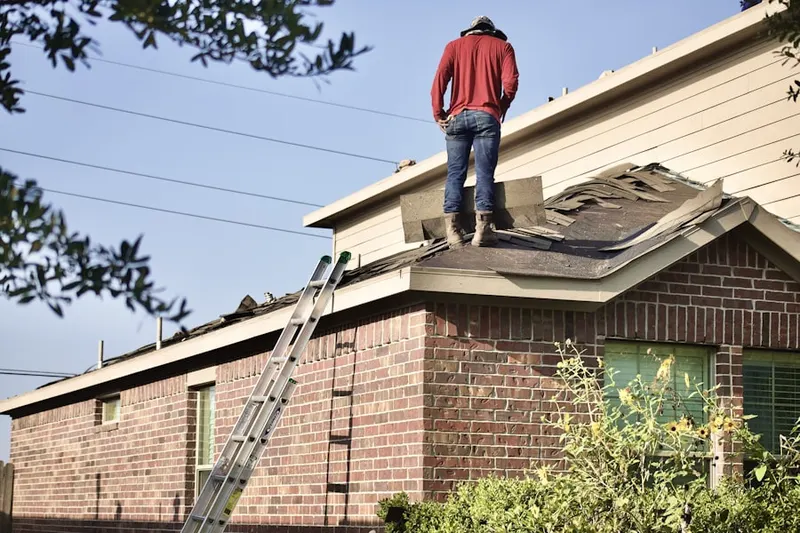 Professional roofer working on a residential roof in Cuero